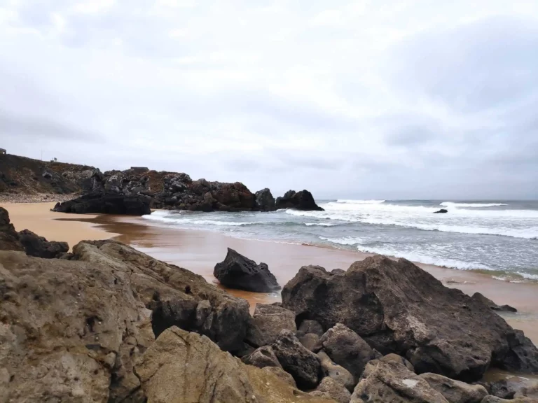 Rock formations line the beach at Praia do Abano