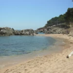 Soft sand and crystal clear water at Cala Estreta nude beach