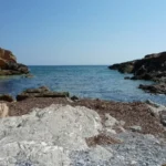 Areas of rocks between the sand at Cala Estreta